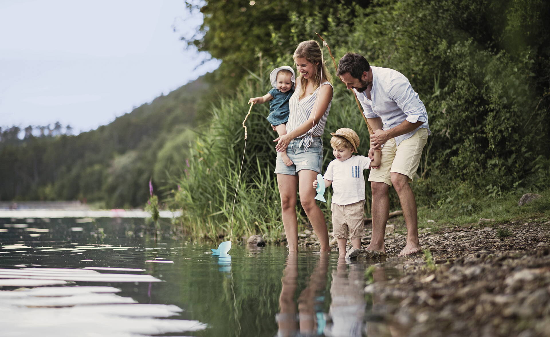 Familie mit zwei kleinen Kindern spielt an der Aare.